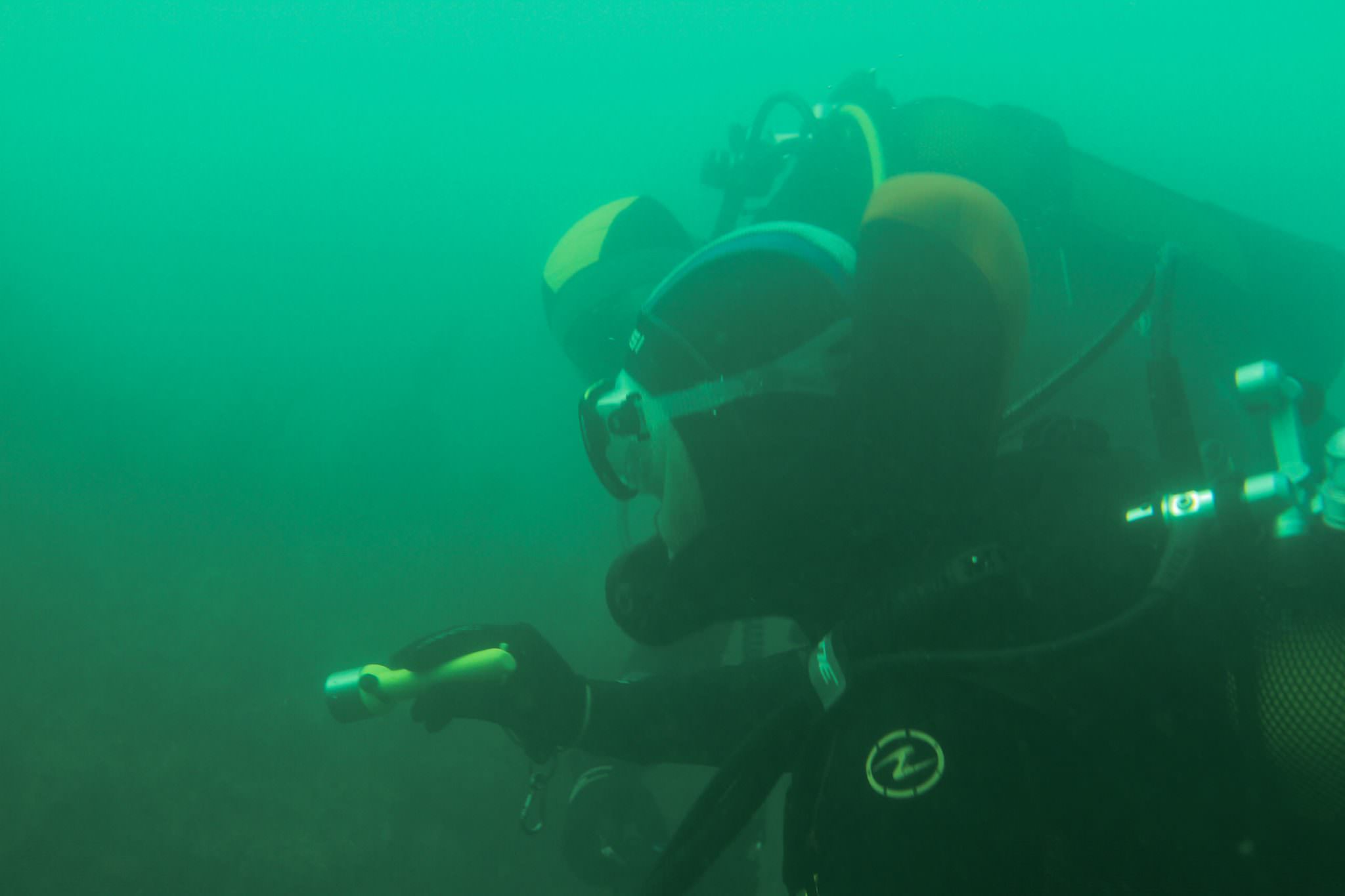 Musée sous-marin à Lorient La Base. Plongeurs sous l'eau, éclairant une épave.