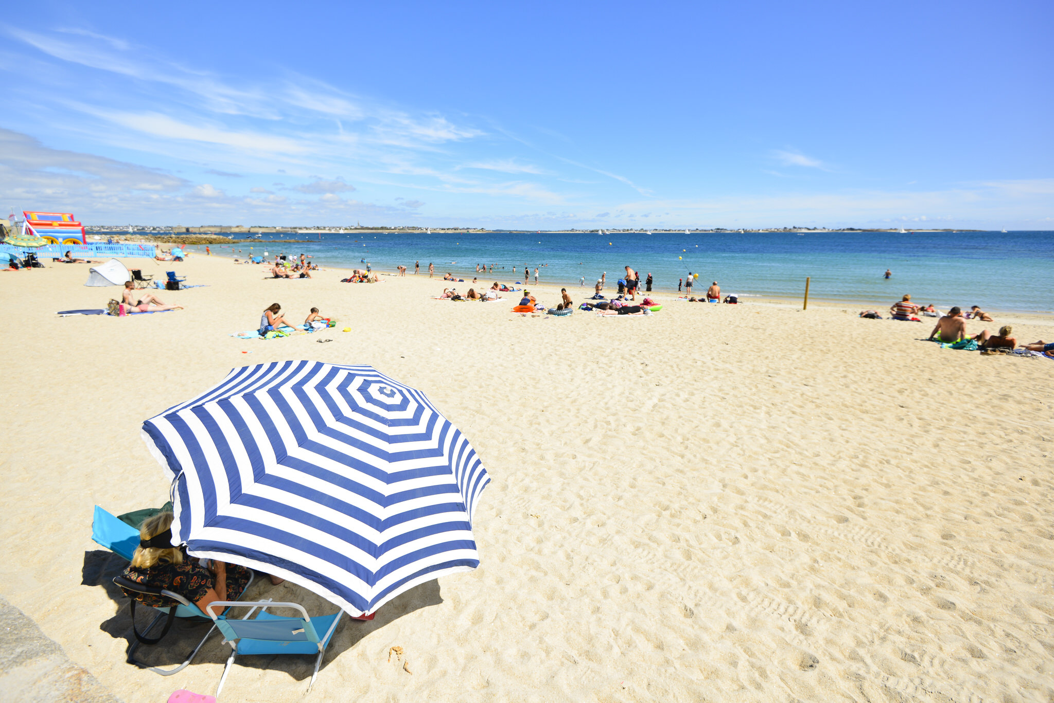 Larmor-Plage, parasol bleu et blanc sur la plage de Port-Maria.