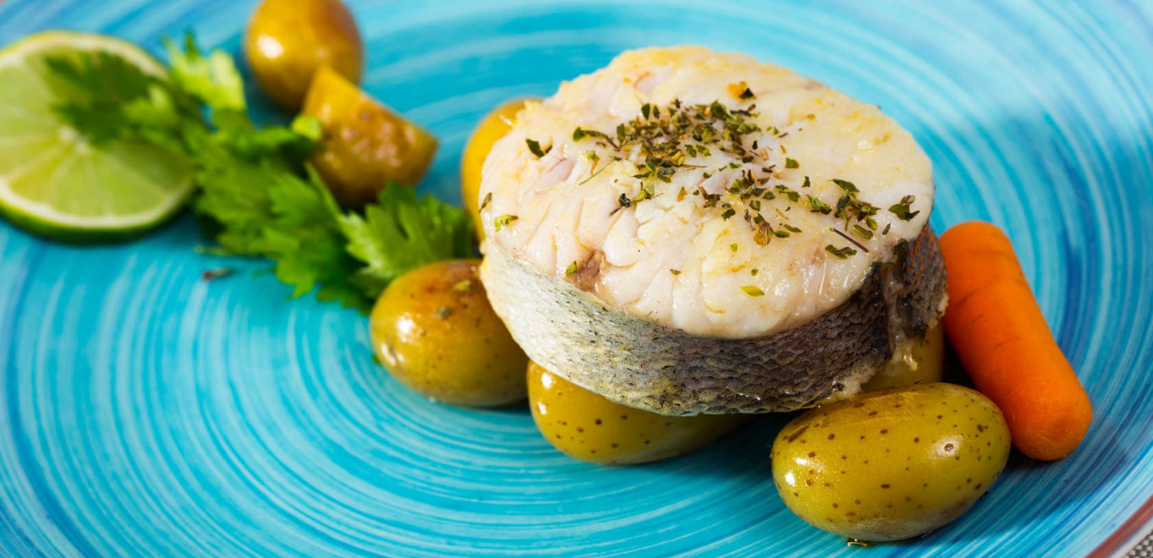 ©Shutterstock. Tranche de merlu au court-bouillon aux aromates, pommes de terre et carottes, à Lorient. Tranche de merlu au court-bouillon aux aromates, pommes de terre et carottes.
